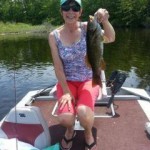 woman in shorts holding a bass from East Grand Lake